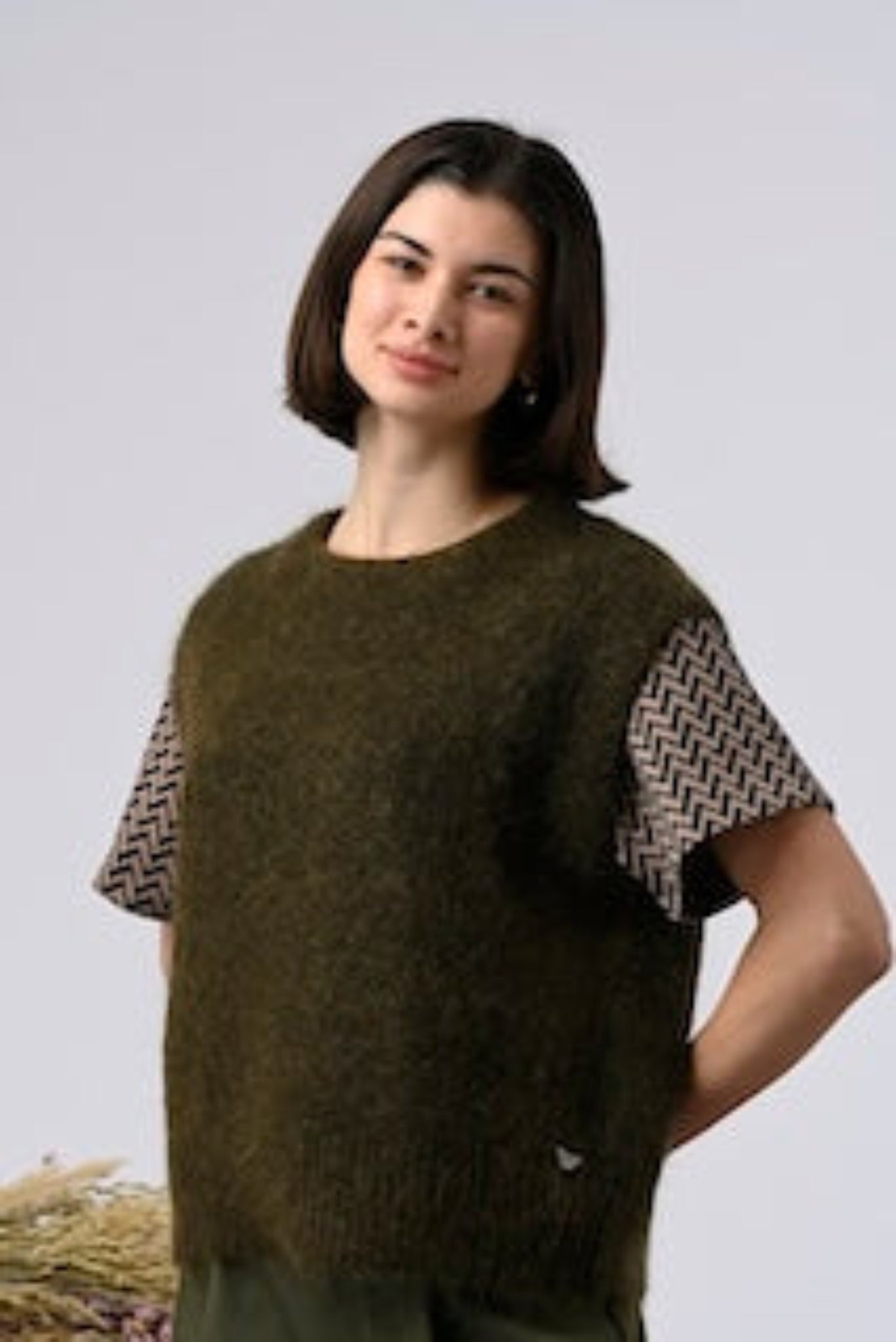 Woman wearing French designer knitwear vest in relaxed fit khaki green
