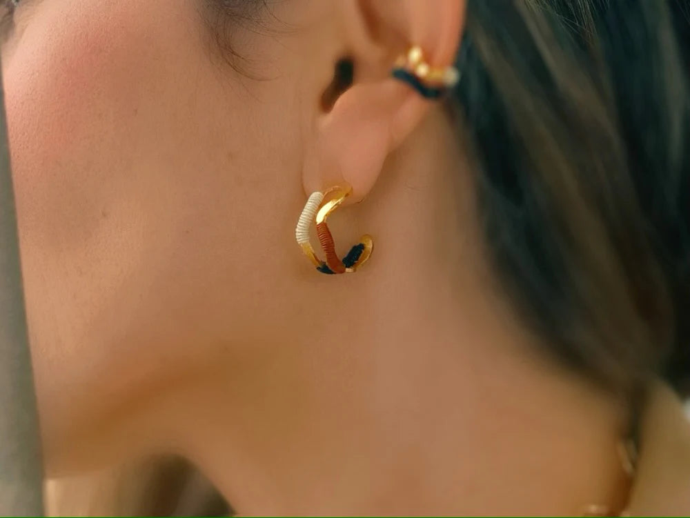 Bamboleira double wave gold hoop earrings handmade in Colombia with natural fibre detail word by model