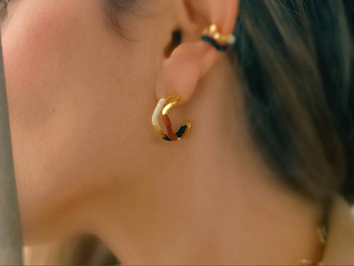 Bamboleira double wave gold hoop earrings handmade in Colombia with natural fibre detail word by model