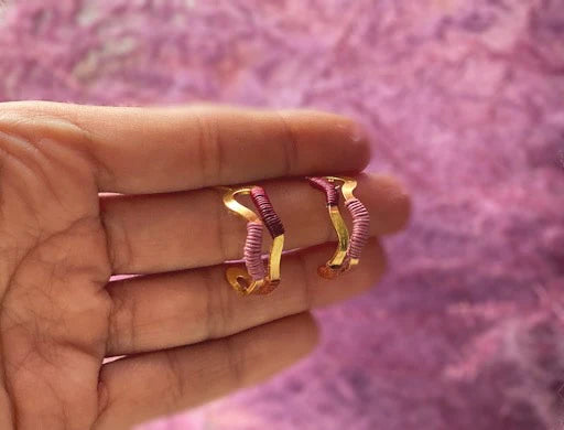Bamboleira hoop earrings in Primrose Pink & Terracotta & Burgundy handcrafted, ecoconscious shown in model's hand