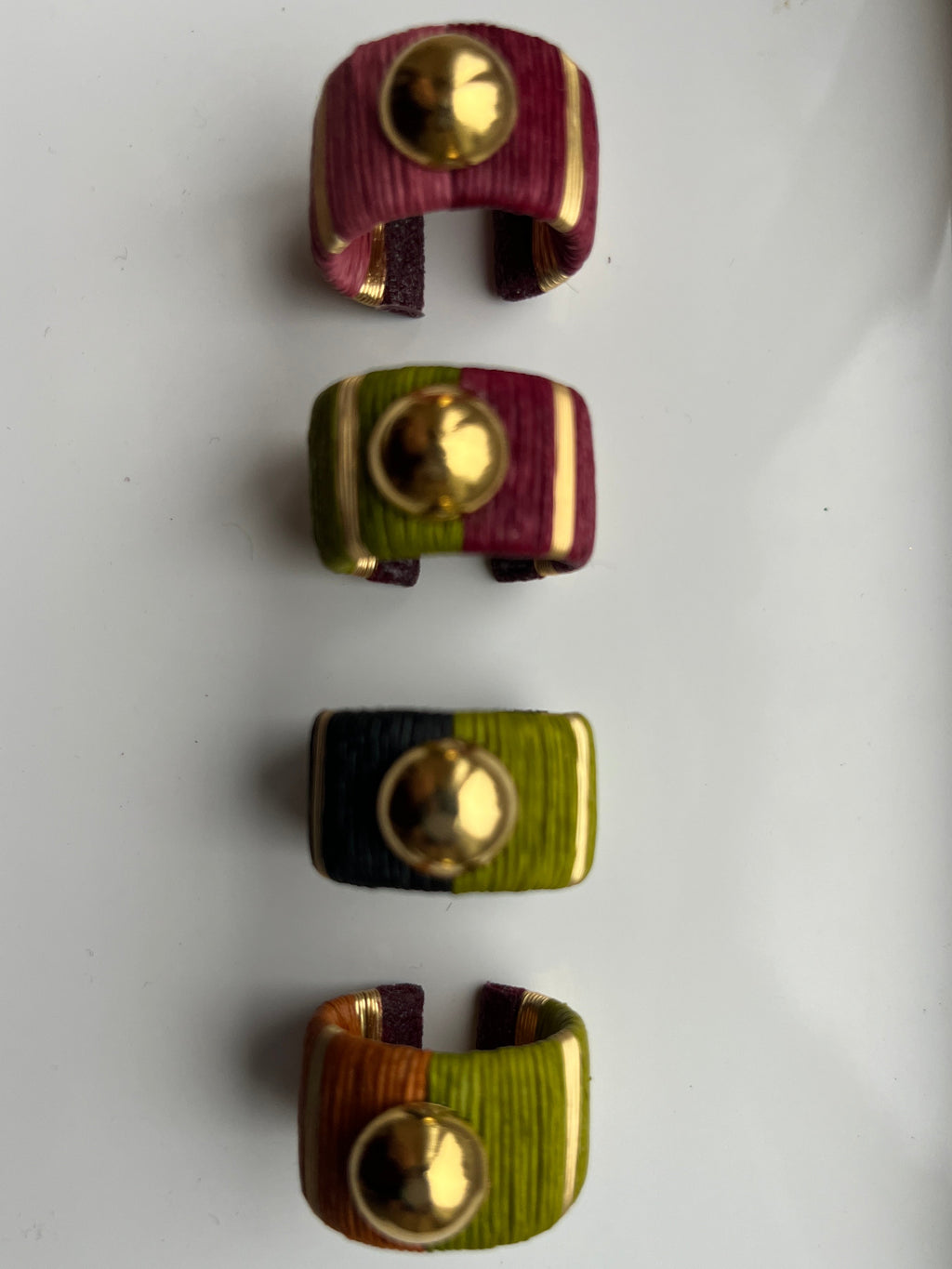 Four rings with gold centers on a white background