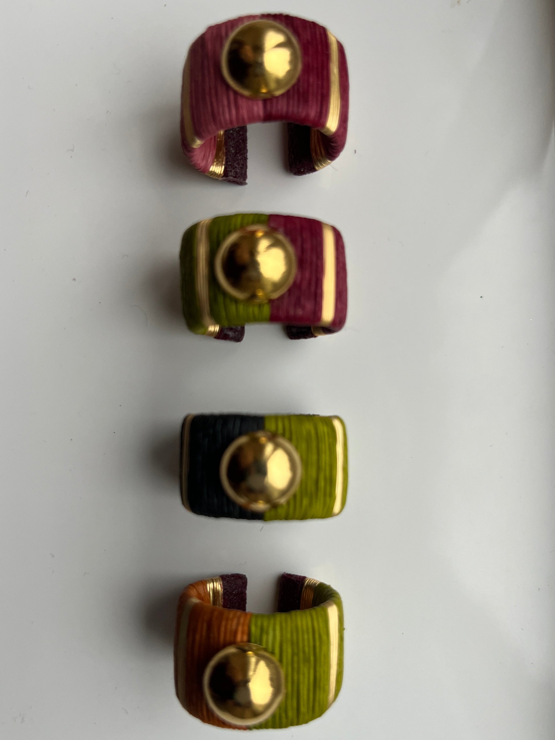 Four rings with gold centers on a white background