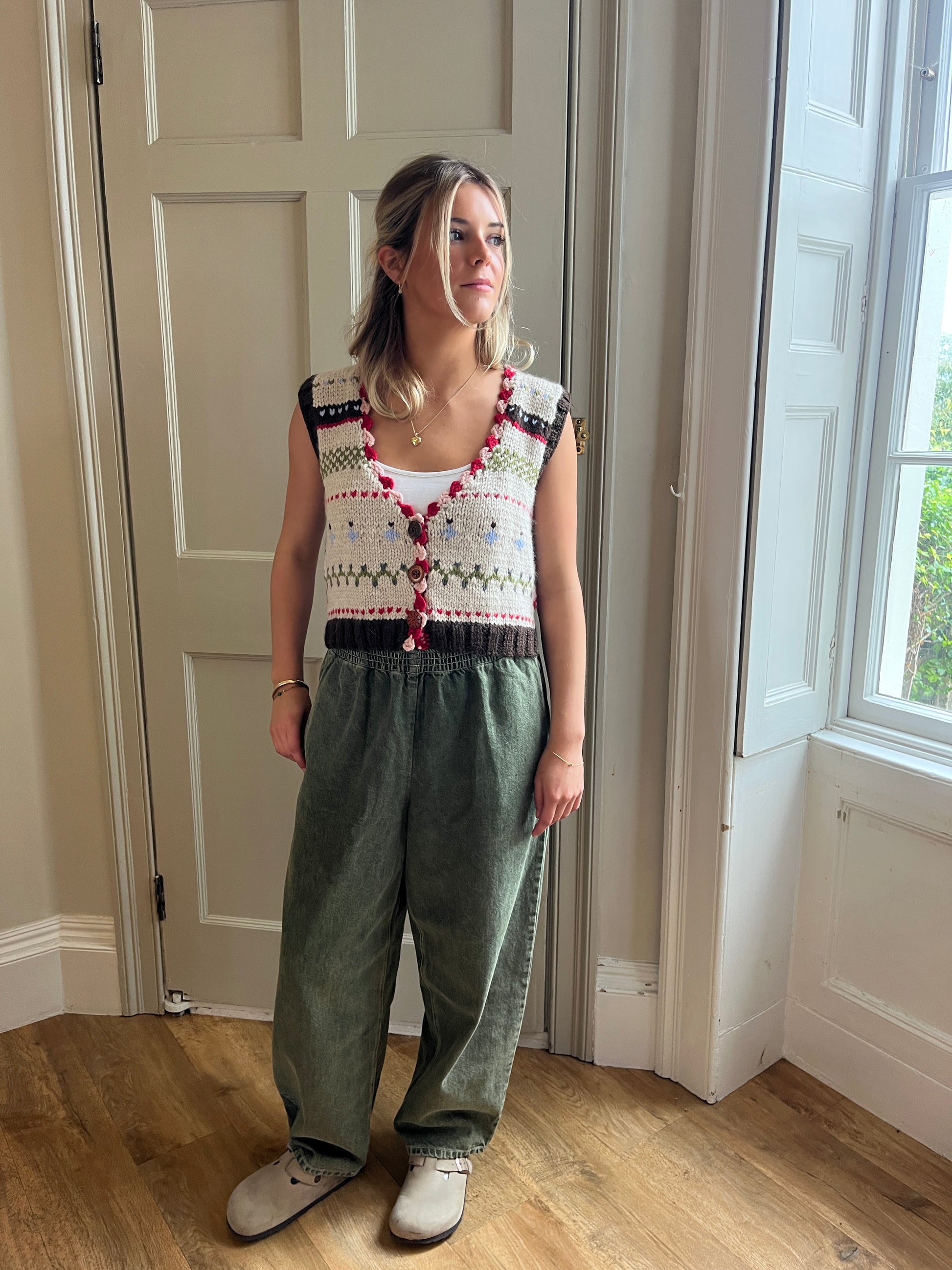 Girl wearing a colorful nicky dupont hand-knitted waistcoat  with scalloped details