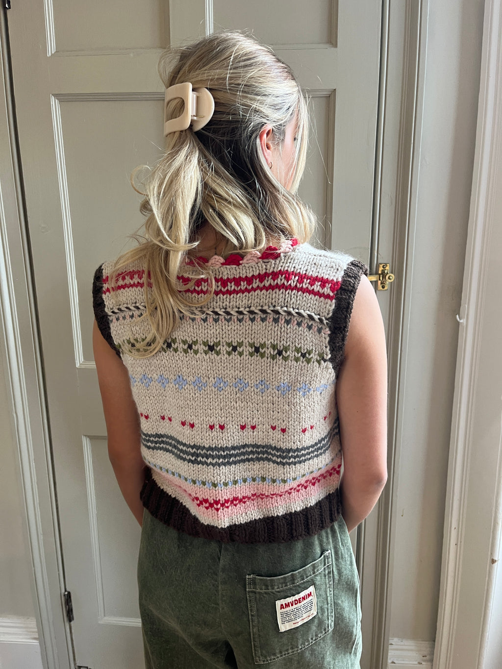 Woman wearing a colorful Nicky Dupont hand-knitted vest shown from behind