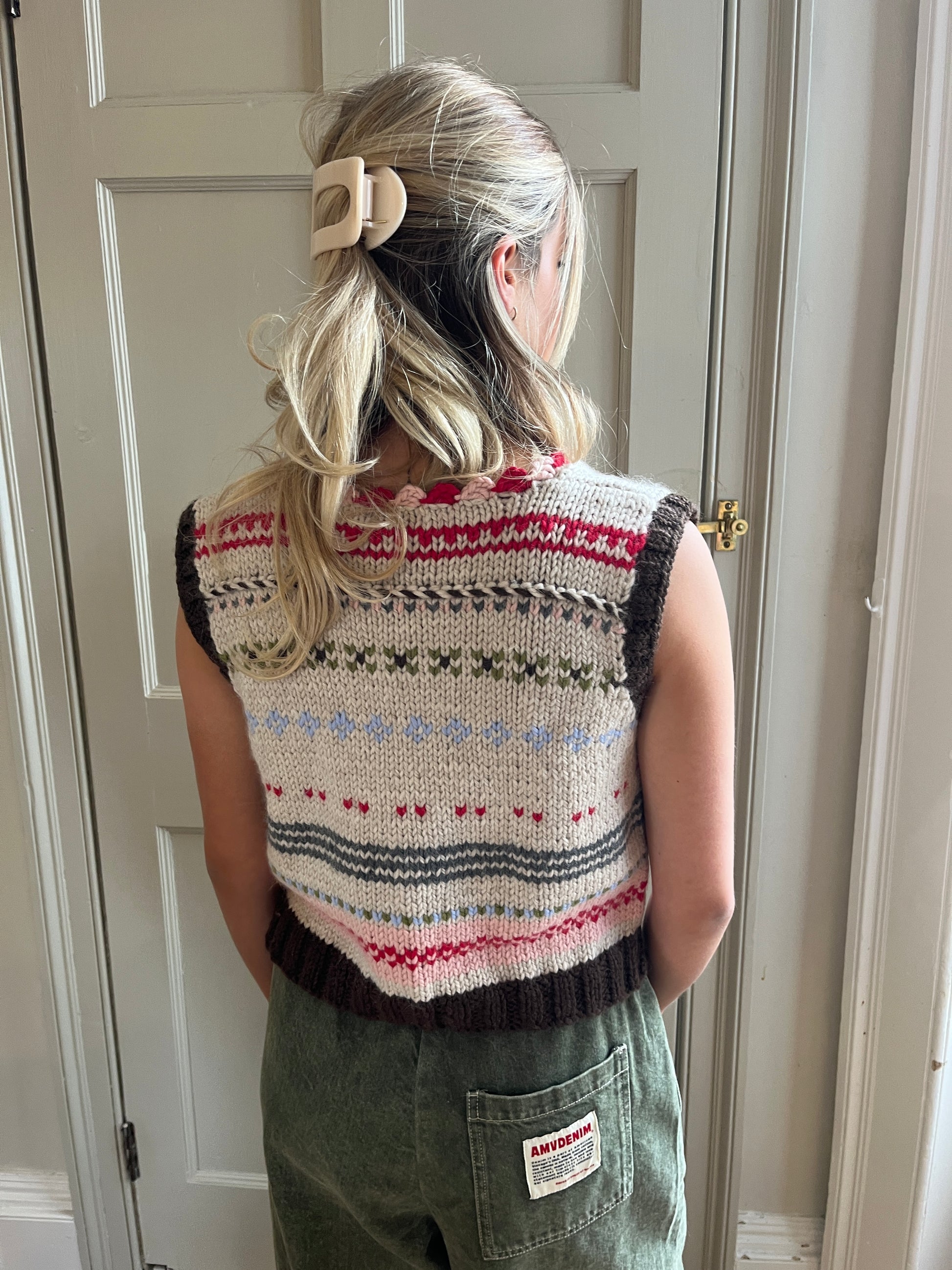 Woman wearing a colorful Nicky Dupont hand-knitted vest shown from behind