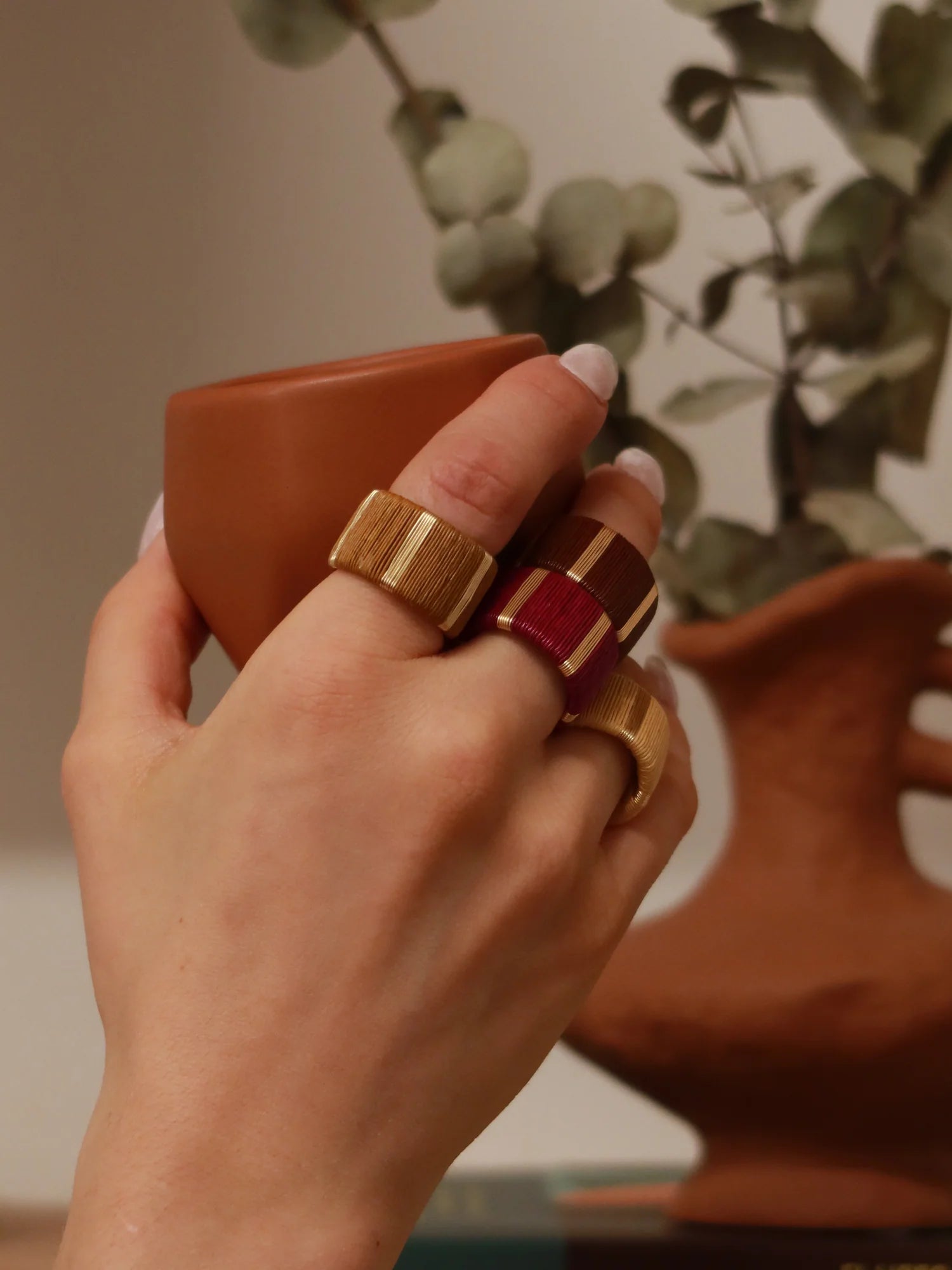 several Handcrafted gold-plated bronze ring with palm fibre shown on a model's hand