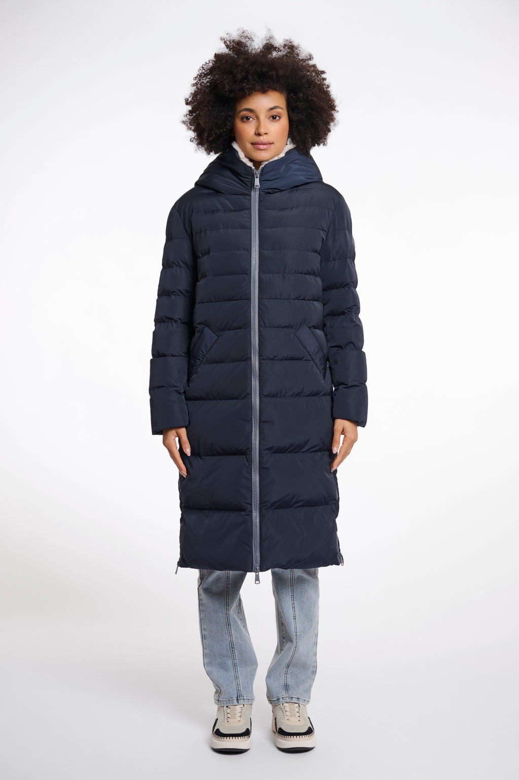Model wearing Rino & Pelle Keila long navy puffa coat with cream faux fur lining 