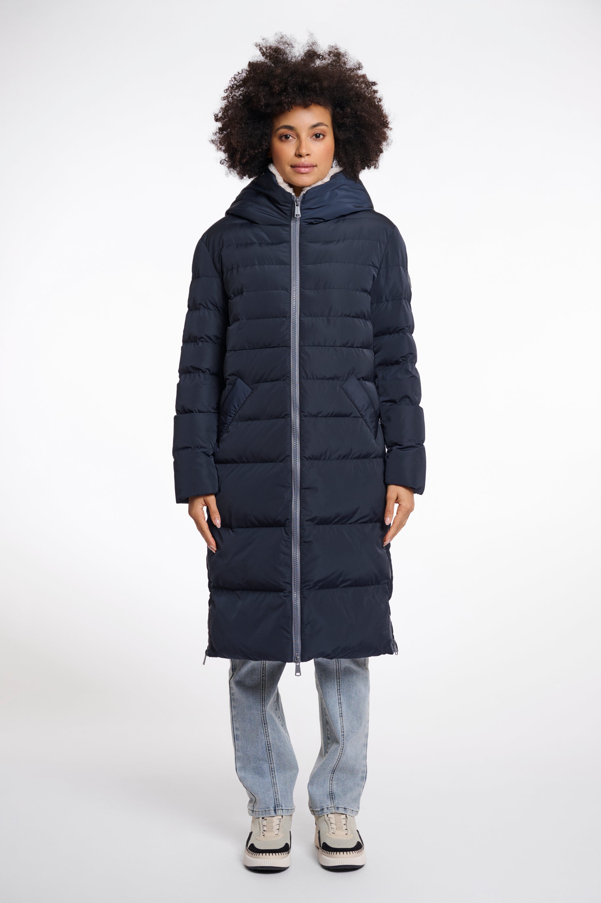 Model wearing Rino & Pelle Keila long navy puffa coat with cream faux fur lining 