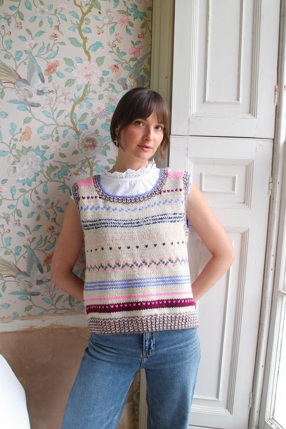 Girl wearing a Nicky Dupont hand knit patterned  vest with colorful accents by window