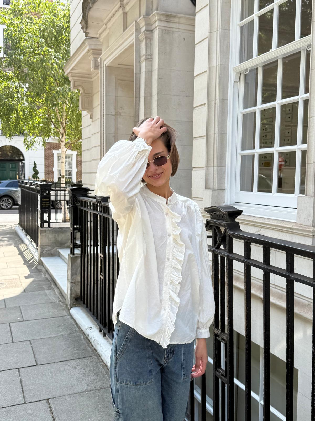 Cream frill shirt in 100% cotton show on model with jeans and sunglasses 