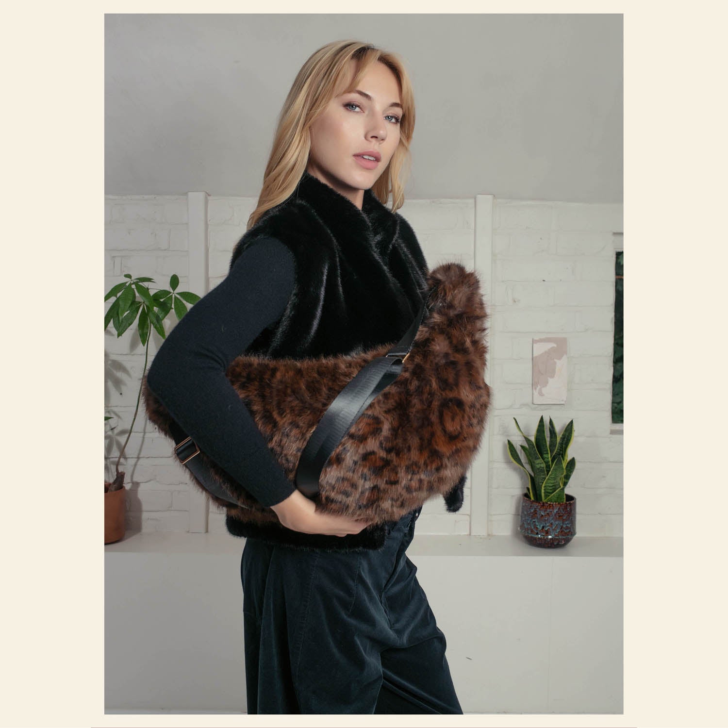 Chocolate faux fur statement bag with leopard pattern held by model
