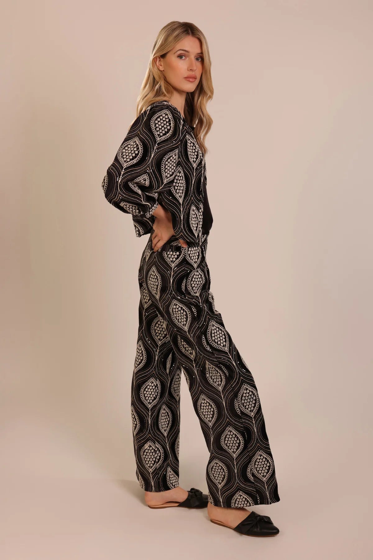Woman wearing a black and white patterned jacket and trousers from Traffic People